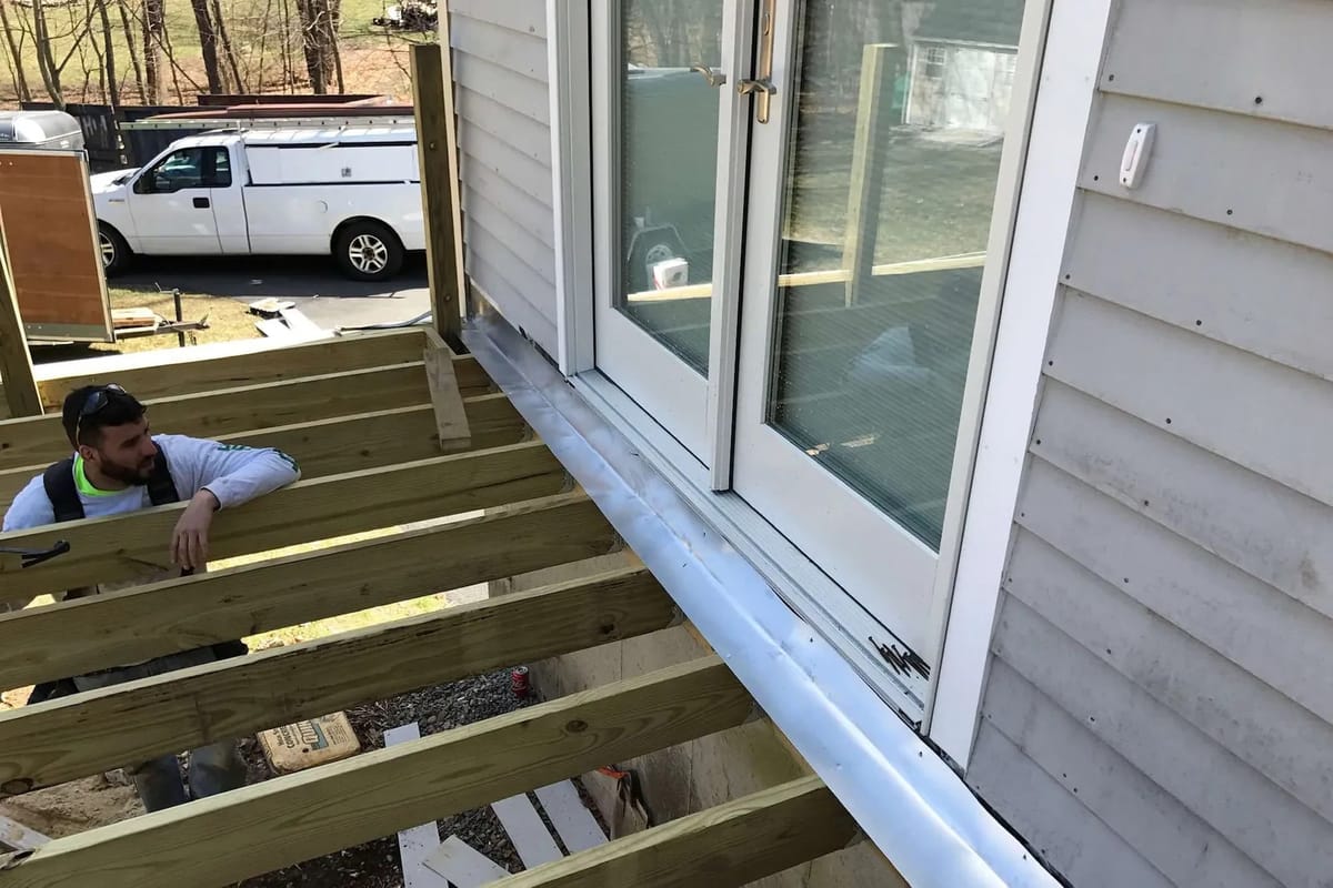 Deck build: joists go in, one by one, right up to the doors