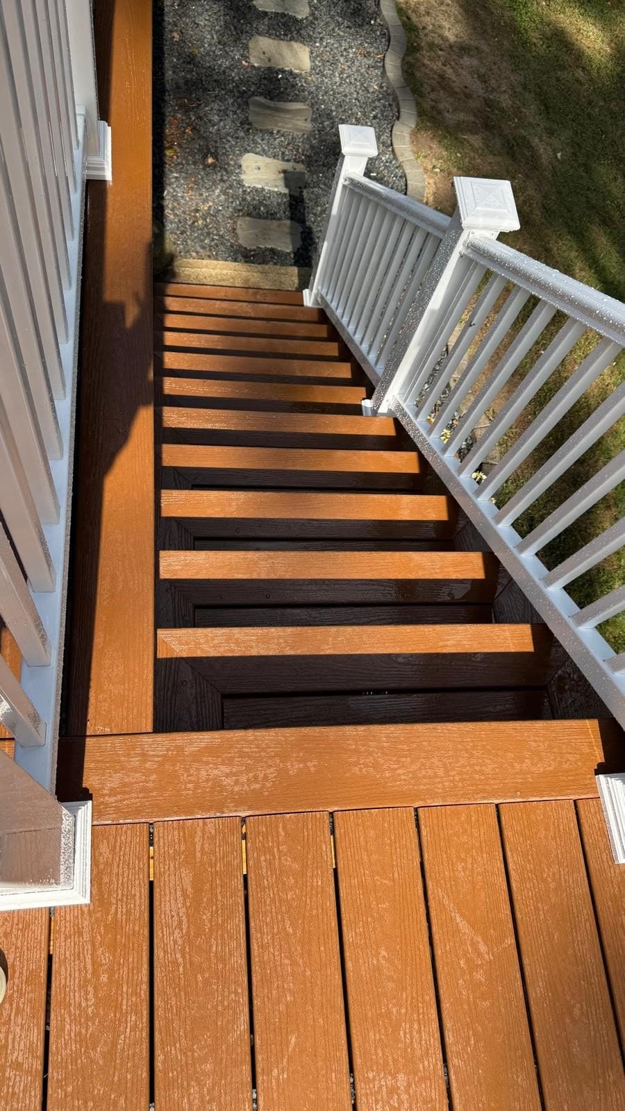Deck renovation in Newton, MA: custom deck staircase featuring composite steps, white PVC railings, and matching post caps for a clean, durable finish
