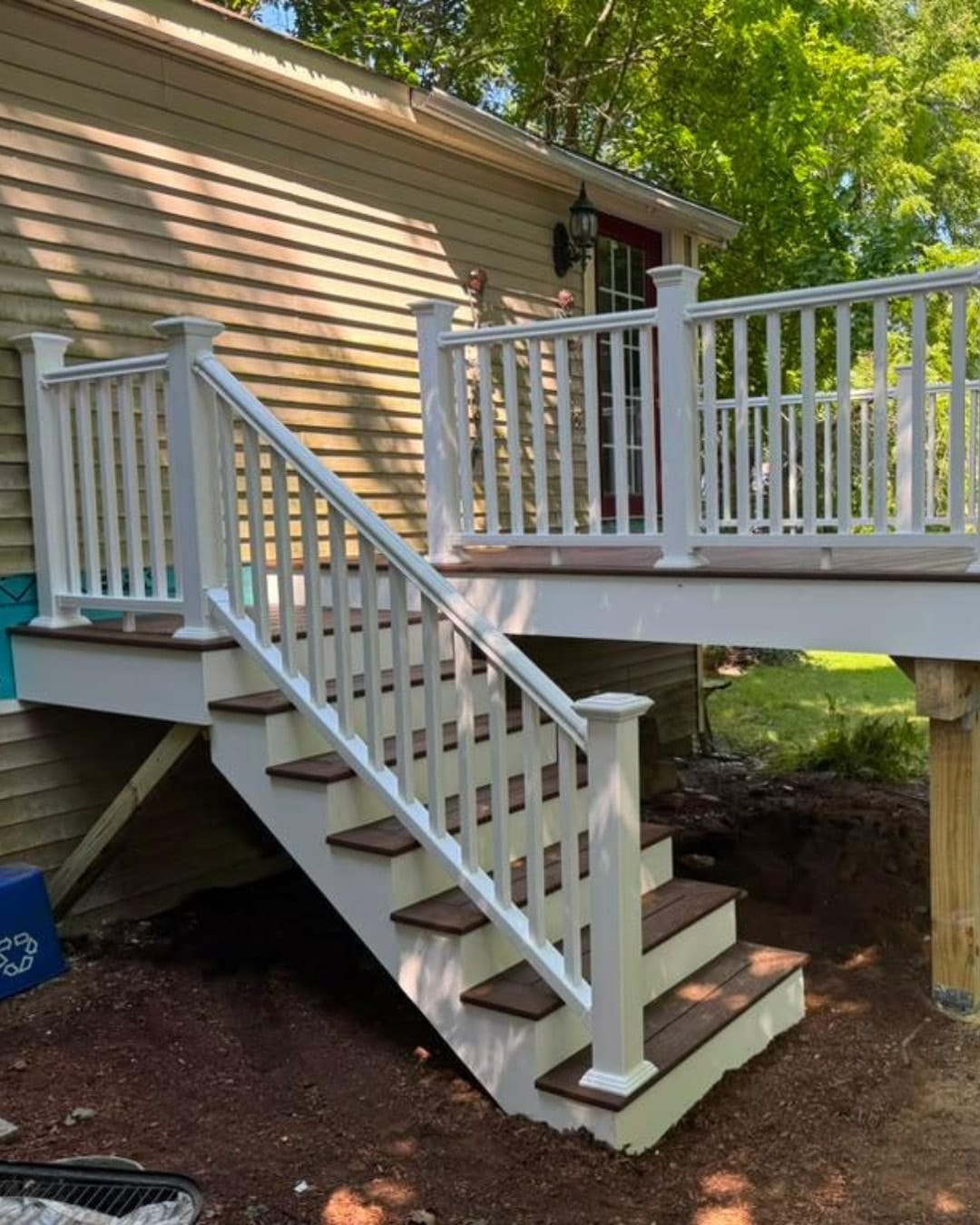 Deck replacement in Marlborough, MA: complete deck replacement featuring brown composite decking, white PVC railings, and matching stairs for a durable, modern outdoor space