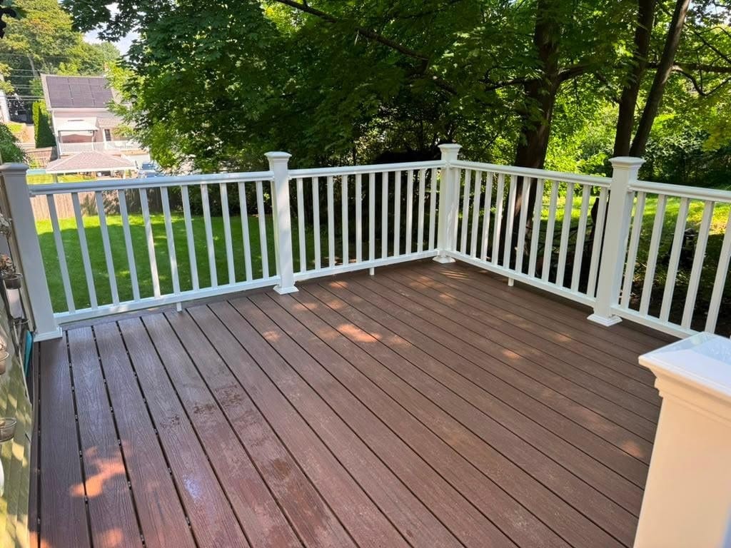 Deck replacement in Marlborough, MA: complete deck replacement featuring brown composite decking, white PVC railings, and matching stairs for a durable, modern outdoor space