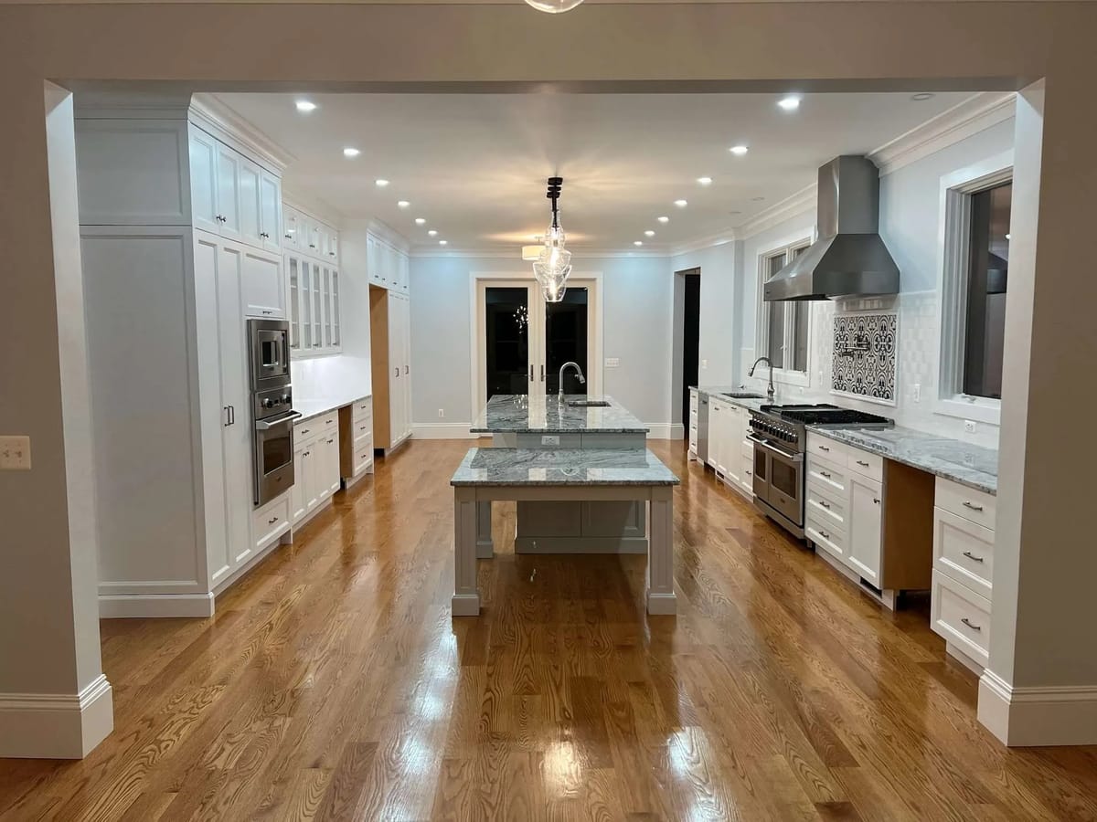 Kitchen remodel: white kitchen with a long stone-topped island