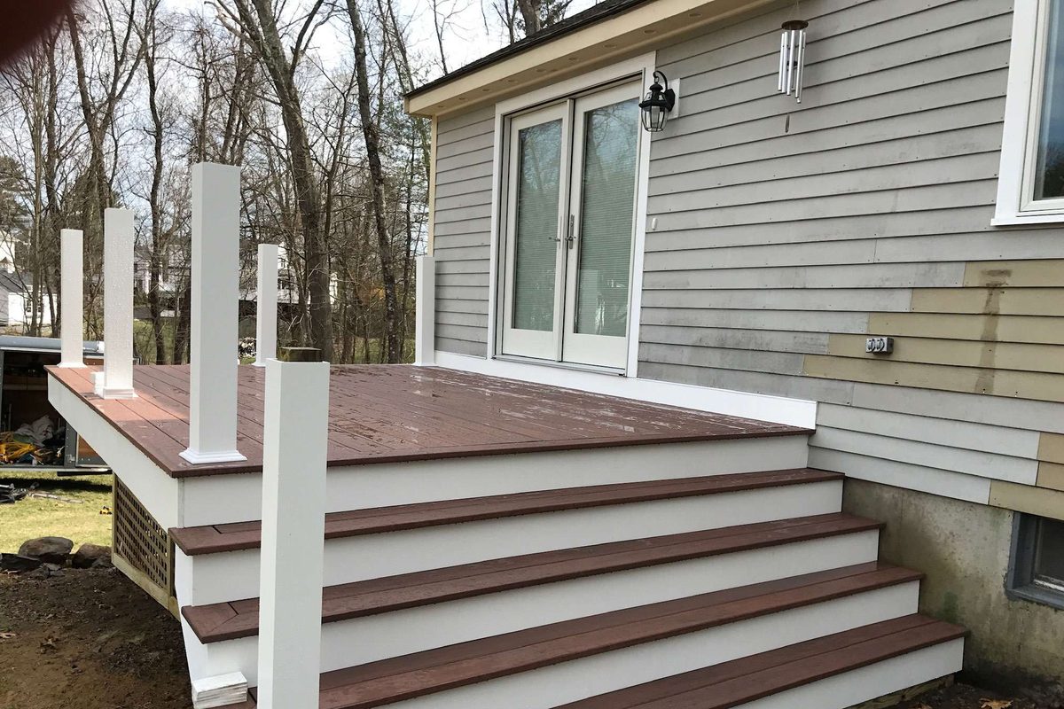 New decking and wide stairs installed, with white posts in place