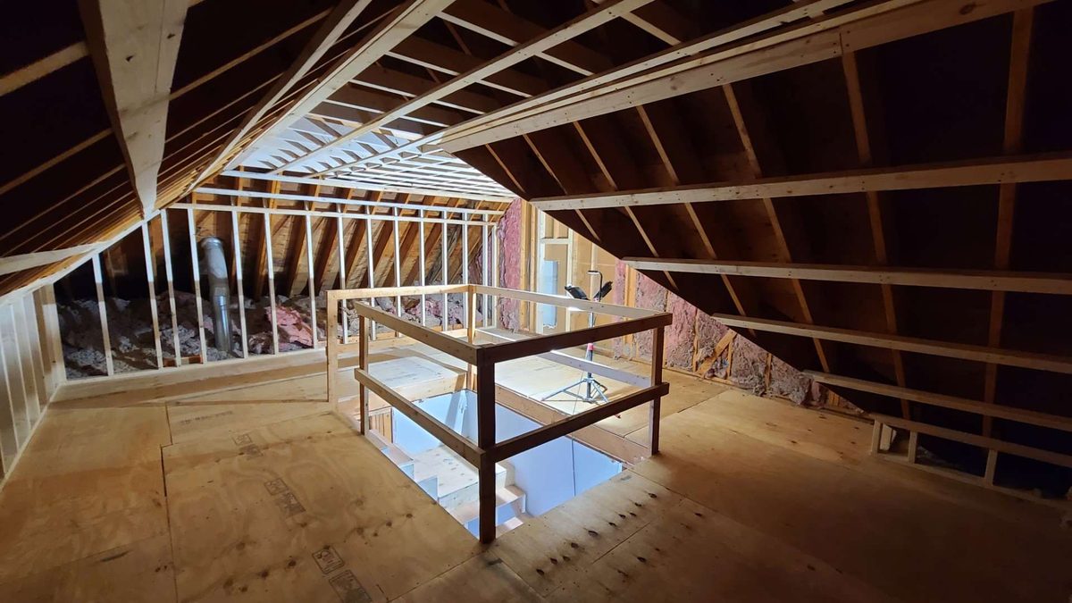 Attic conversion in progress, with new framing and a stair opening under the roof rafters