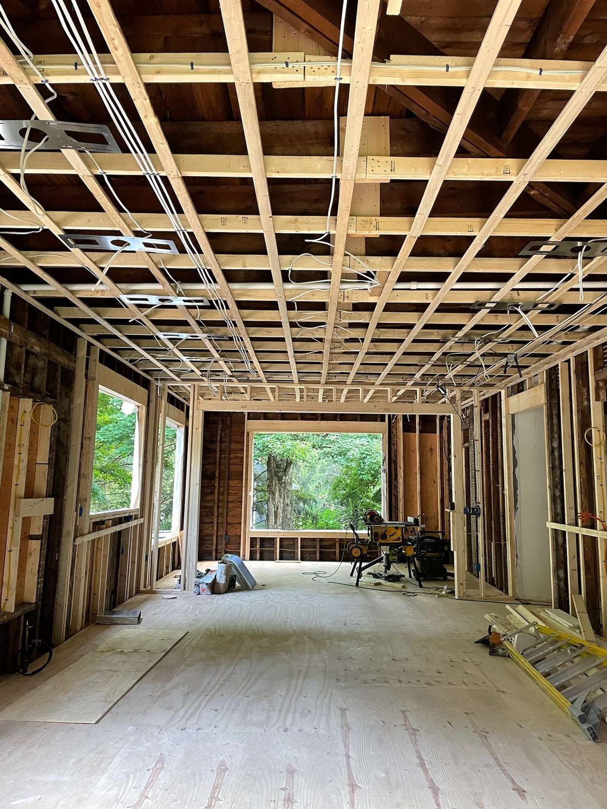 Interior renovation at framing stage, with new ceiling joists and large window openings
