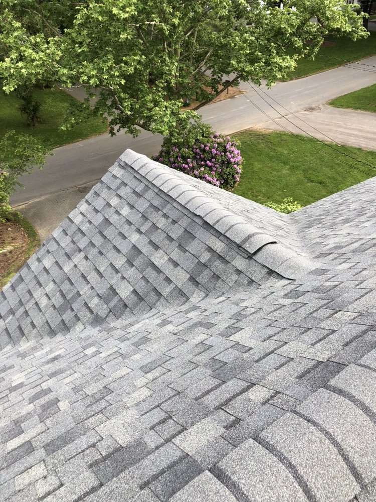 New asphalt shingles meeting at a roof hip, seen from above